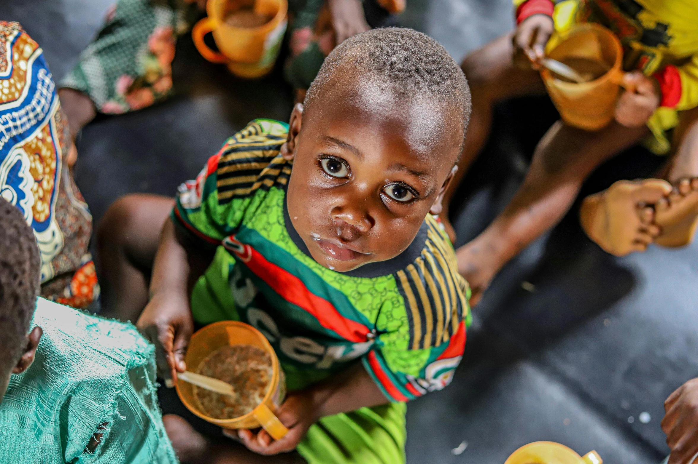 a group of children sitting next to each other, by Daniel Lieske, pexels contest winner, hurufiyya, bowl filled with food, african aaron paul, soup, thumbnail