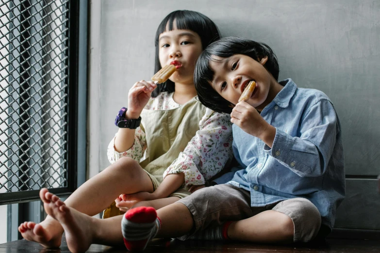 a couple of little girls sitting next to each other, pexels contest winner, snacks, zeen chin and terada katsuya, boys, holding a baguette