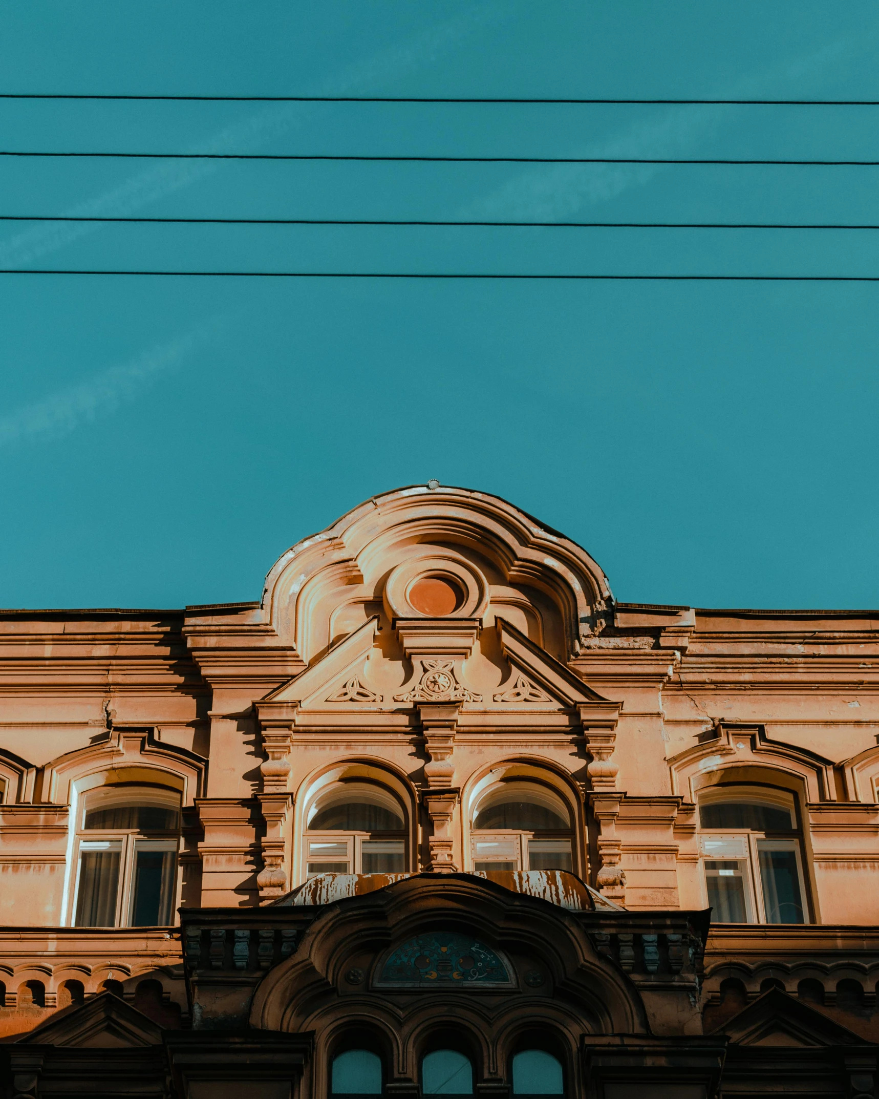 a tall building with a clock on top of it, pexels contest winner, neoclassicism, brown and cyan color scheme, khreschatyk, vaporwave mansion, wires hanging across windows