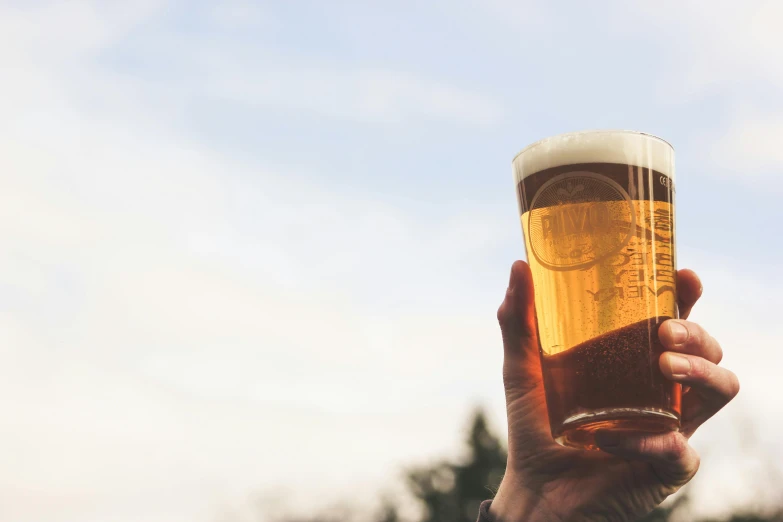 a person holding a glass of beer in their hand, pexels contest winner, bright sky, instagram post, no watermarks, 15081959 21121991 01012000 4k