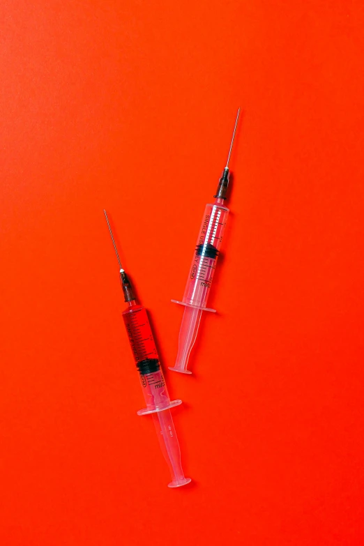 two sylls sitting next to each other on an orange background, by Niko Henrichon, pexels, holding a syringe!!, red filter, blue blood, it has a red and black paint