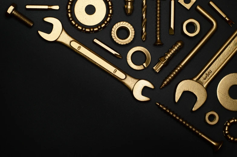 a bunch of tools sitting on top of a table, gold black, plain background, bolts, intricate design