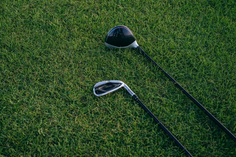 a golf club sitting on top of a lush green field, unsplash, realism, shiny reflective surfaces, avatar image, levers, evenly lit