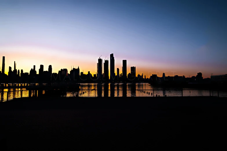 a large body of water with a city in the background, by Farid Mansour, minimalism, sunset panorama, museum quality photo, silhouette :7, many skyscrapers