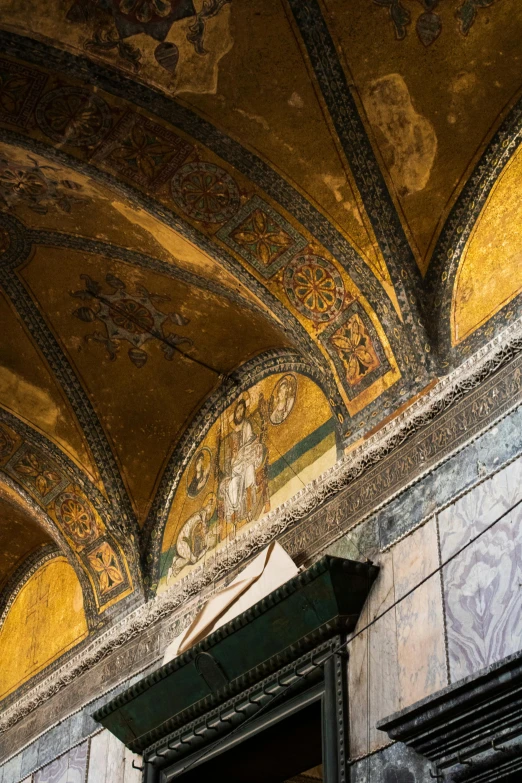 a clock mounted to the side of a building, a mosaic, inspired by Taddeo Gaddi, trending on unsplash, renaissance, mosque interior, yellow robes, high arched ceiling, golden feathers