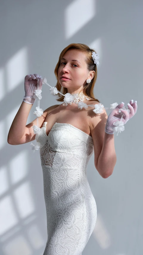 a woman in a white dress and gloves, inspired by Méret Oppenheim, pexels contest winner, wearing bra, white petal, demur, made of lab tissue