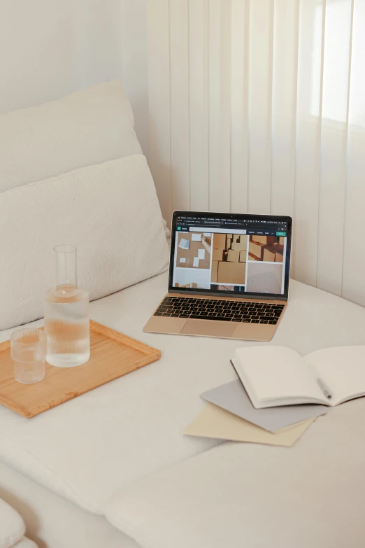 a laptop computer sitting on top of a bed next to a glass of water, a computer rendering, trending on unsplash, renaissance, light beige pillows, architect, behance lemanoosh, plain background