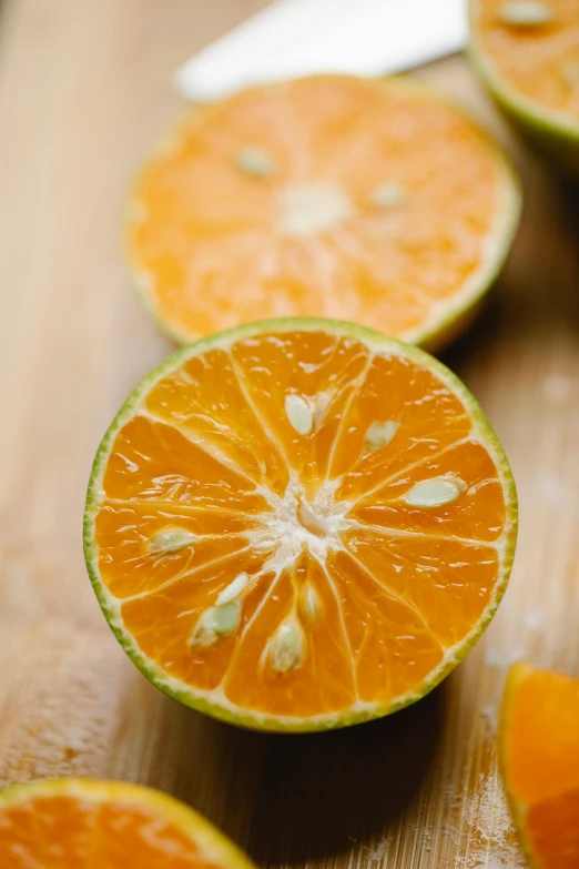 sliced oranges on a cutting board with a knife, shin hanga, bright green dark orange, subtle detailing, up close, lime