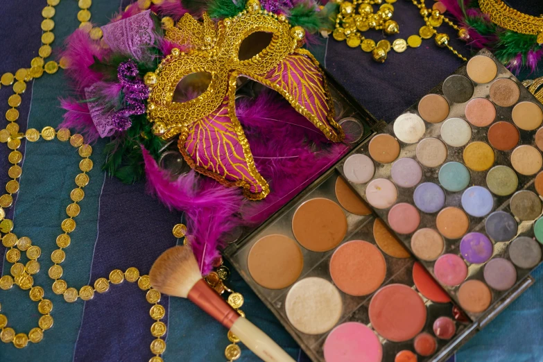 a close up of a box of makeup on a table, inspired by Mardi Barrie, renaissance, carnival background, diverse costumes, gold mask, purple