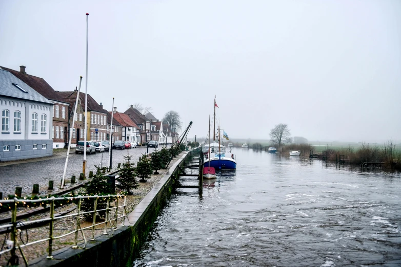 a body of water that has a bunch of boats in it, by Schelte a Bolswert, pexels contest winner, happening, river flowing through a wall, winter, thumbnail, big overcast