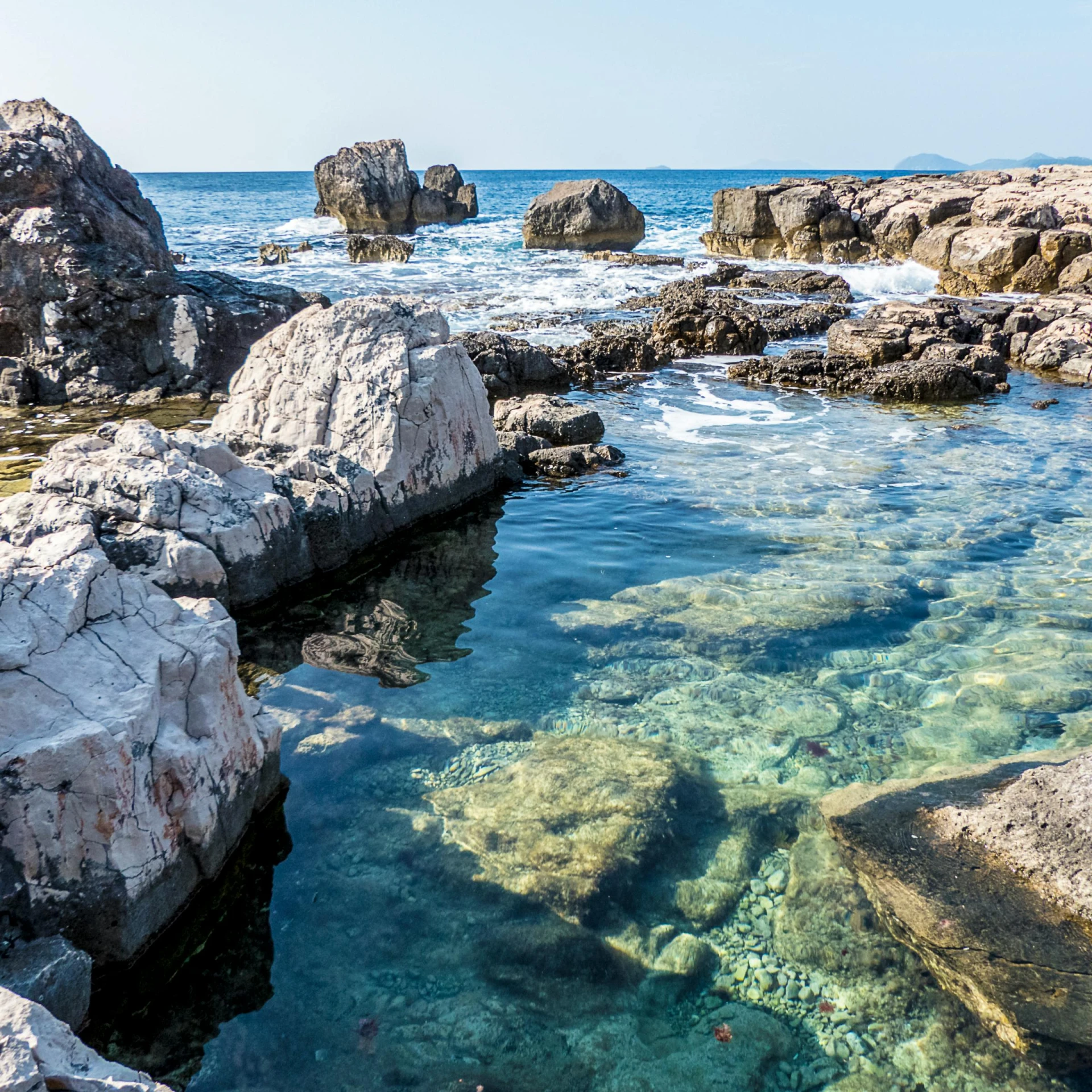 a body of water surrounded by large rocks, pexels contest winner, mingei, glass antikythera, rock pools, thumbnail, croatian coastline