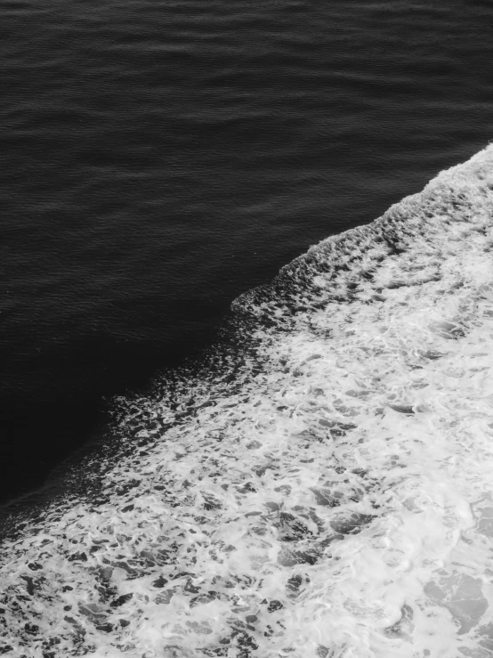 a black and white photo of a body of water, a black and white photo, by Alexis Grimou, unsplash, half and half, sea of milk, color contrast, oceanside