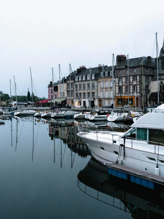 a number of boats in a body of water, a photo, inspired by Pierre Toutain-Dorbec, pexels contest winner, renaissance, peaceful evening harbor, french architecture, vibrant but dreary, high quality photo