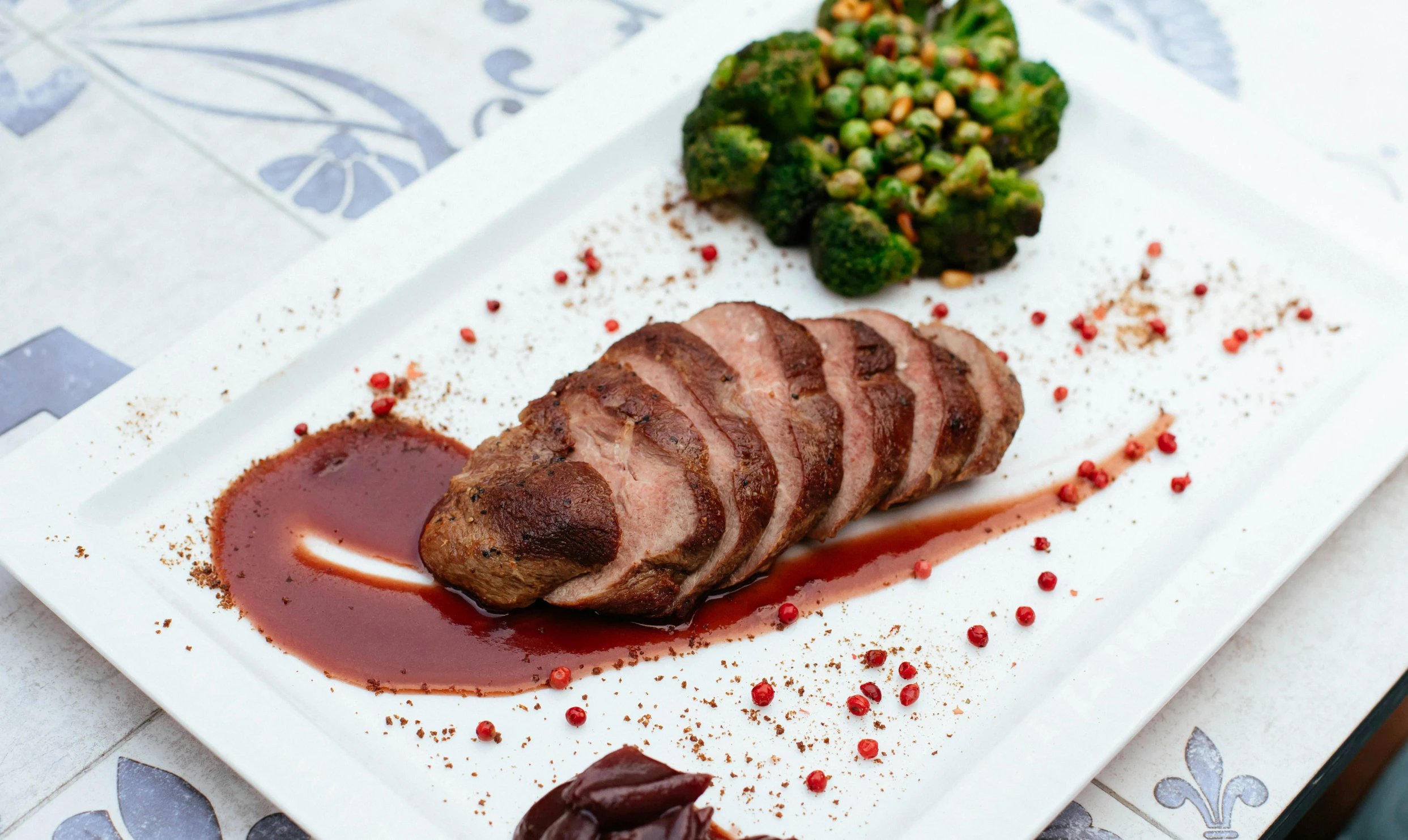 a white plate topped with meat and broccoli, by Julia Pishtar, duck, mattell, caparisons, pointè pose