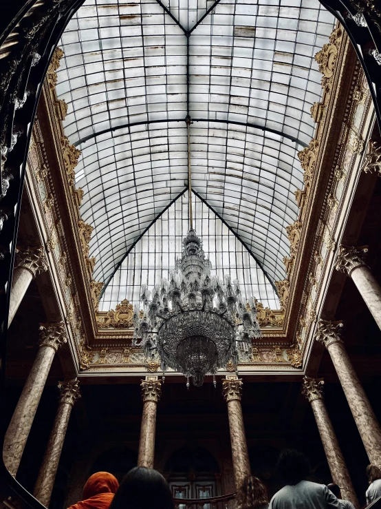a group of people standing inside of a building, inspired by Albert Guillaume, unsplash contest winner, baroque, crystal column, high ceiling, demur, stone and glass and gold