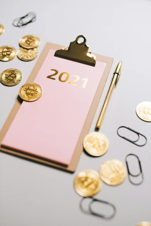 a clipboard sitting on top of a table next to coins, by Julia Pishtar, private press, new years eve, crypto, thumbnail, pink and gold