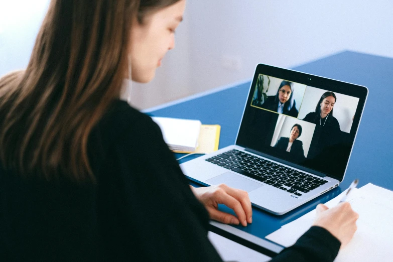 a woman sitting at a desk using a laptop computer, by Julia Pishtar, pexels, video art, in meeting together, rectangle, 1x, profile picture