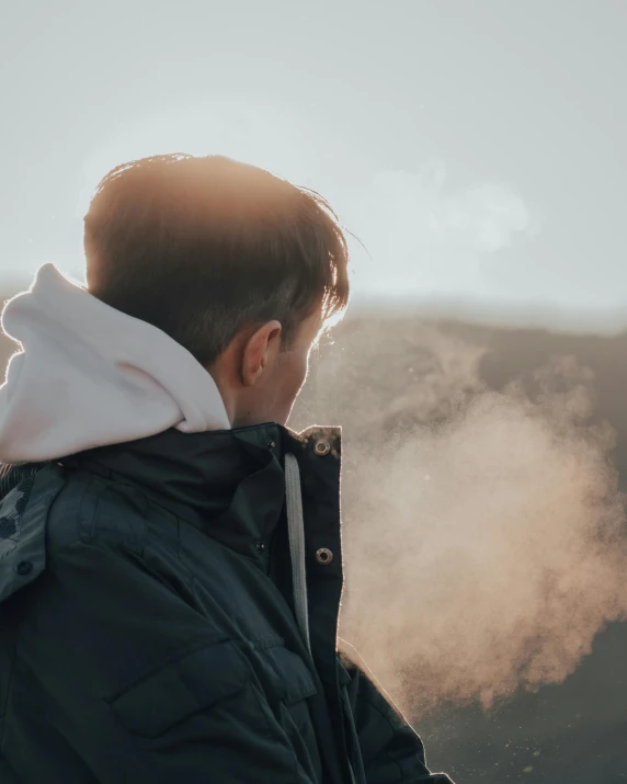 a man smoking a cigarette on top of a mountain, by Emma Andijewska, trending on pexels, young boy, lgbt, man wearing a closed cowl, misting