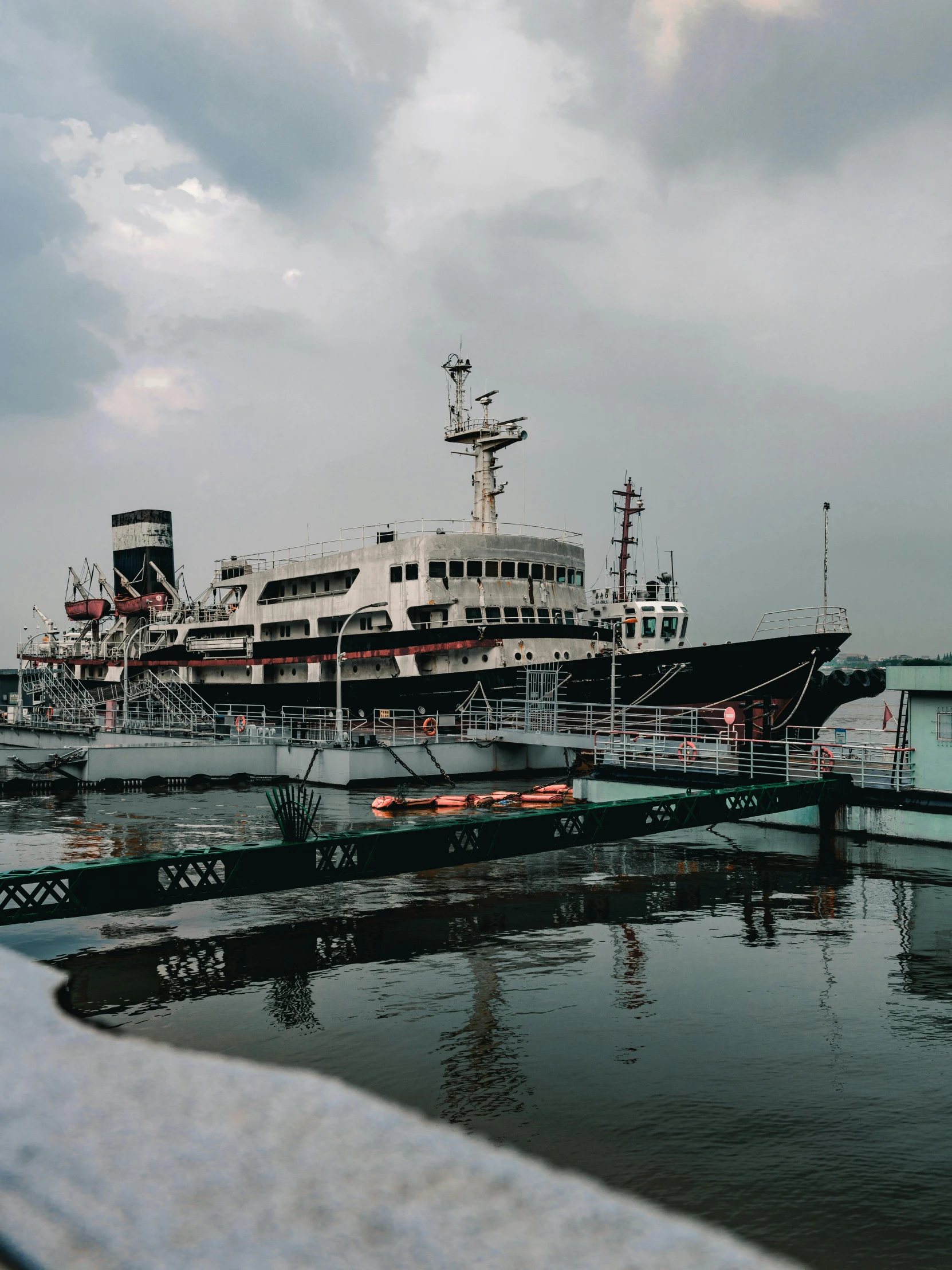 a large boat sitting on top of a body of water, a colorized photo, inspired by Elsa Bleda, pexels contest winner, modernism, soviet yard, jakarta, trending on vsco, lomography lady grey