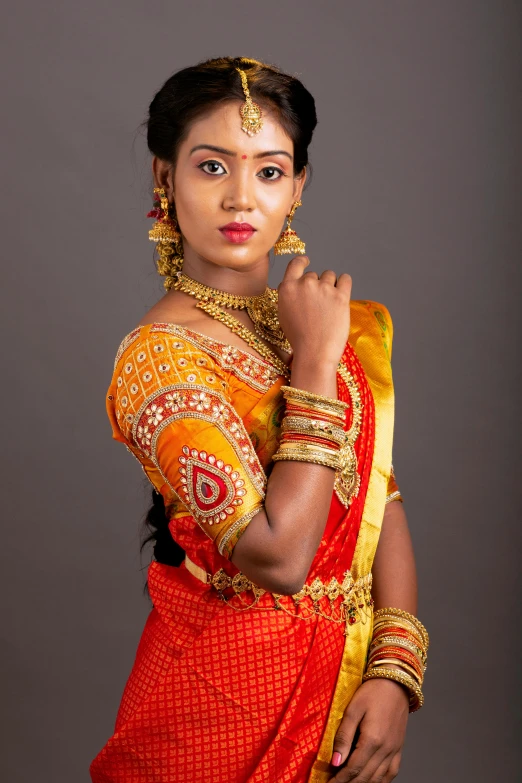 a woman in a red and yellow sari, inspired by T. K. Padmini, trending on cg society, hurufiyya, studio photoshoot, promo shoot, * * * * *, slide show