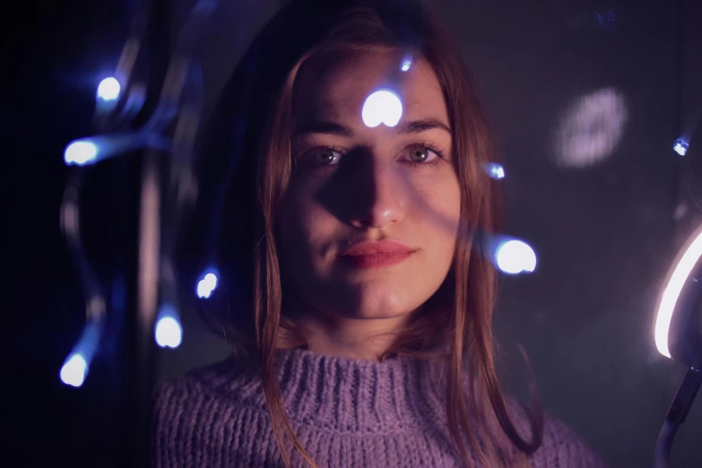 a close up of a person holding a cell phone, a portrait, pexels contest winner, light and space, fairy lights, portrait of sanna marin, purple volumetric lighting, portrait 8 k