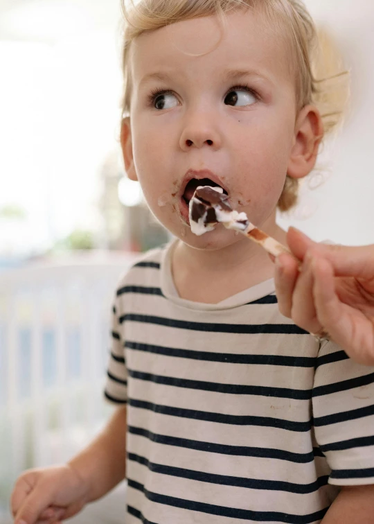 a little boy eating a piece of cake, pexels, photorealism, white with chocolate brown spots, high quality photo, ignant, eyvind