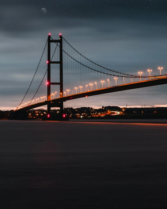 a bridge over a body of water at night, by John Henderson, pexels contest winner, hull, grey skies, famous photo, at dusk at golden hour