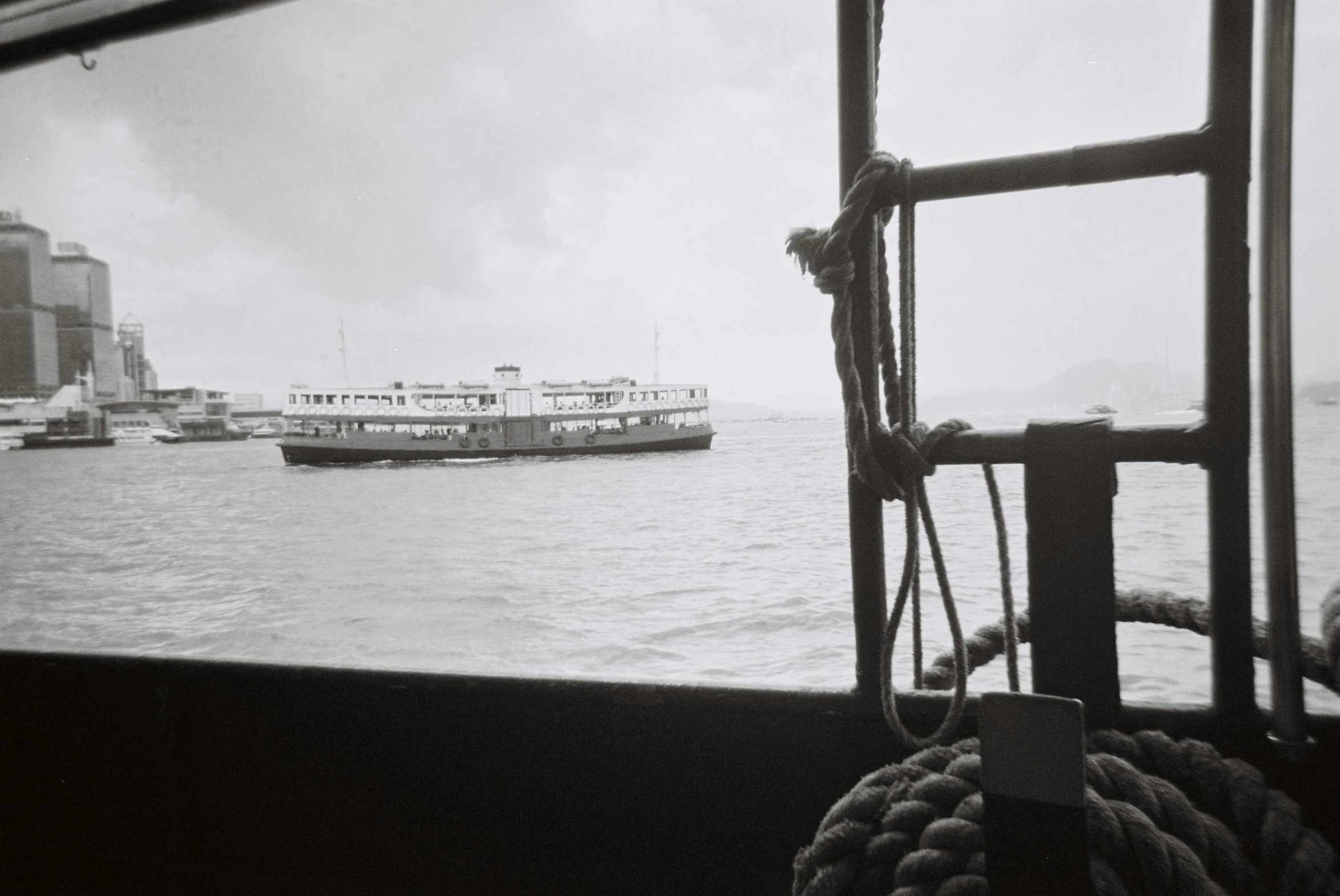 a black and white photo of a boat in the water, a black and white photo, inspired by Bert Hardy, hong kong 1 9 5 4, interior of staten island ferry, colour photograph, government archive photograph