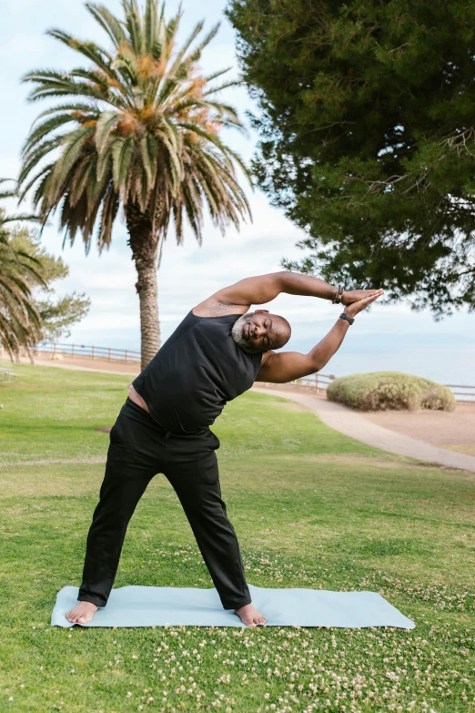 a man doing a yoga pose in a park, by Winona Nelson, samuel l jackson, ocean view, hollywood promotional image, plus-sized