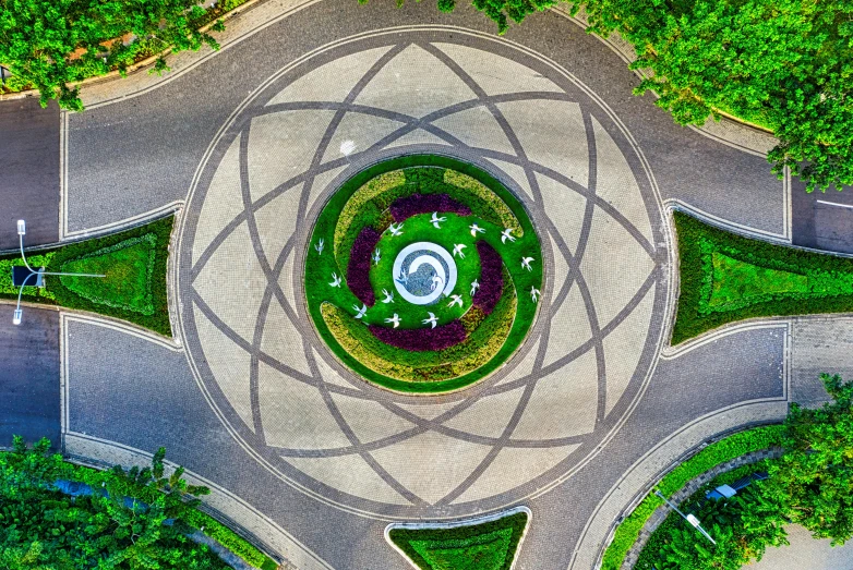 an aerial view of a roundabout surrounded by trees, a mosaic, pexels contest winner, land art, yantra, exterior botanical garden, dimensional portal, jakarta