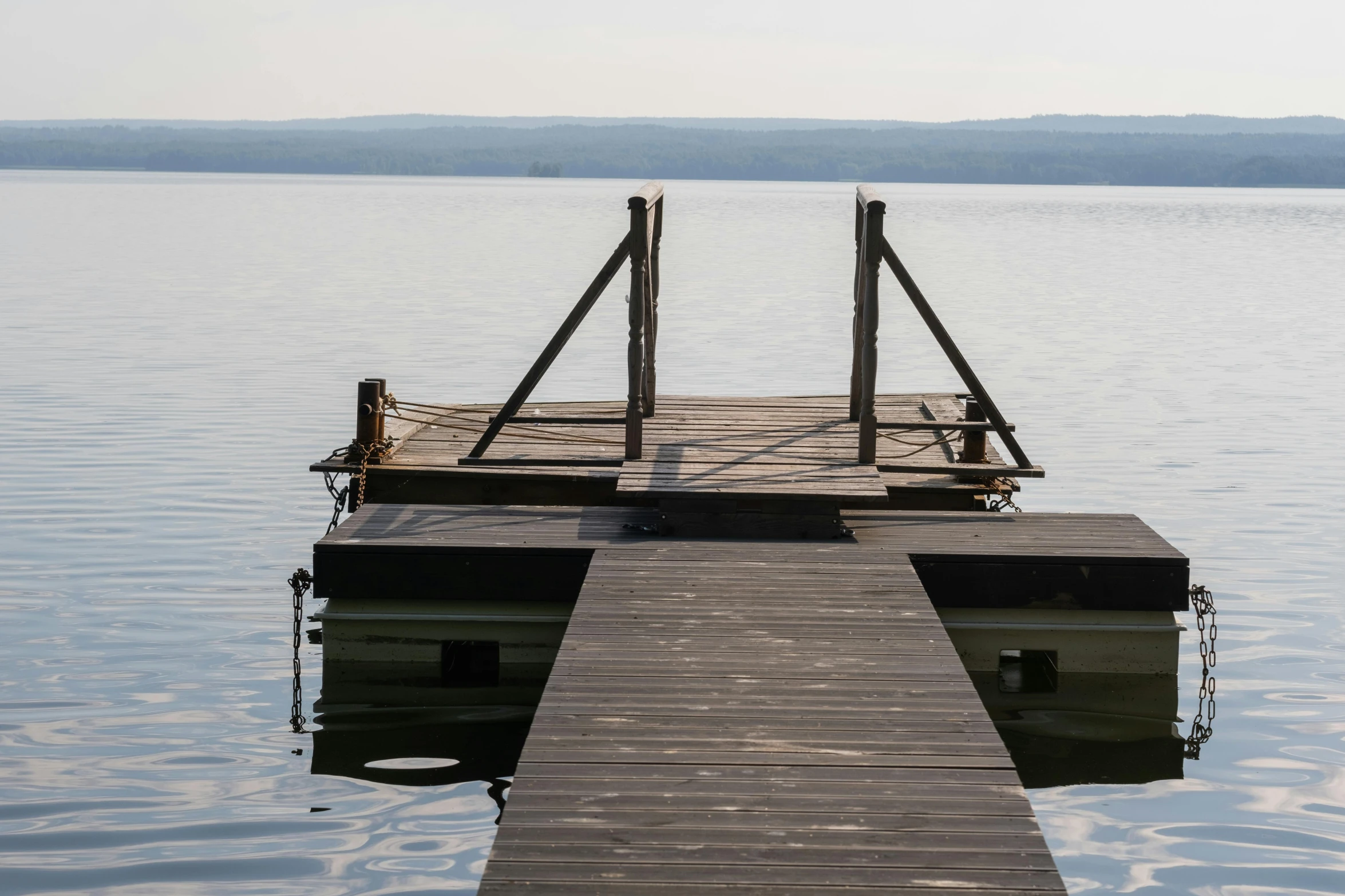 a dock in the middle of a large body of water, an album cover, inspired by Otakar Sedloň, unsplash, peaceful day, brown, uncropped, moored