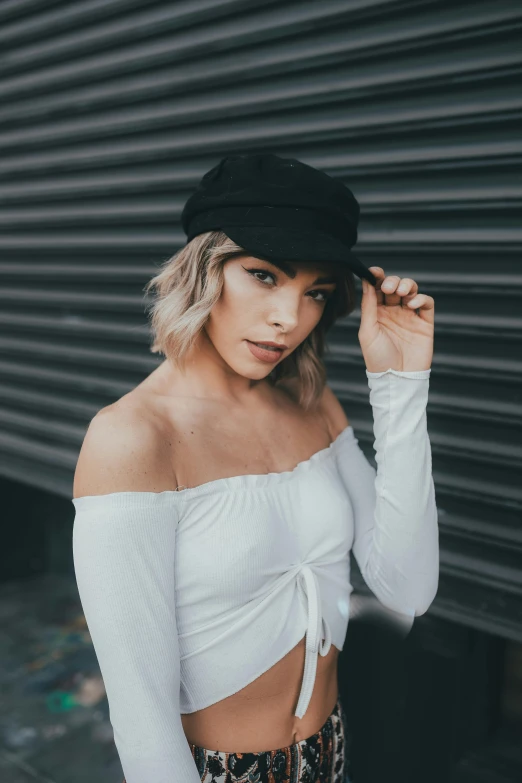a woman wearing a white top and leopard print pants, a photo, inspired by Elsa Bleda, trending on pexels, black cap, curled silver hair, cinematic outfit photo, looking her shoulder