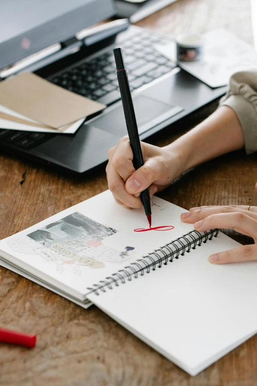 a person sitting at a desk writing on a notebook, a drawing, professional online branding, very artistic, studious, scrapbook