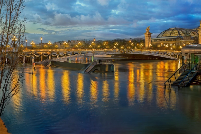 a bridge over a body of water under a cloudy sky, by Daniel Gelon, pexels contest winner, art nouveau, parisian street at night, panoramic, fan favorite, golden hour photo