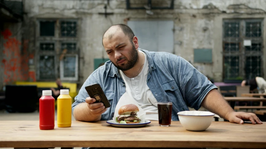 a man sitting at a table with a plate of food, pexels contest winner, hyperrealism, holding a very advance phone, big moe, demna gvasalia, plus-sized