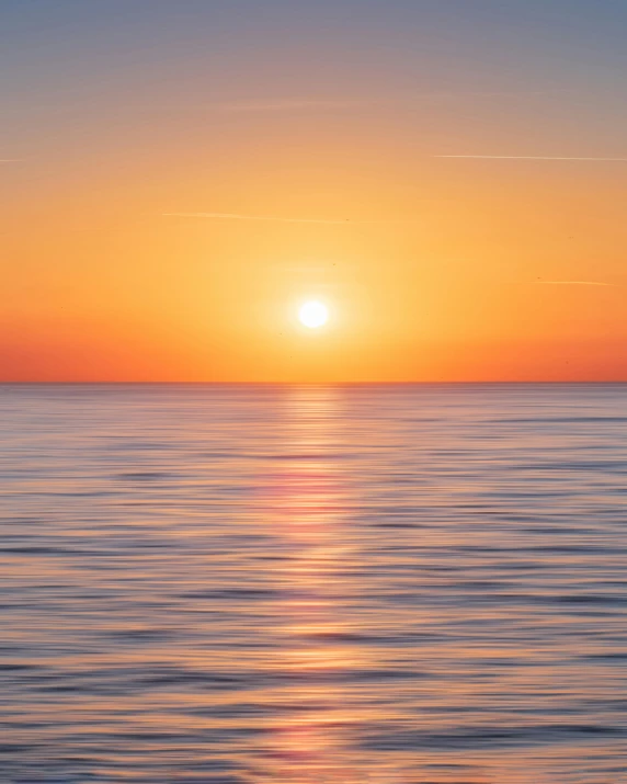 a large body of water with a sunset in the background, by Jacob Toorenvliet, pexels, minimalism, the glimmering orange dawn, a photo of the ocean, the sun is shining, today\'s featured photograph 4k
