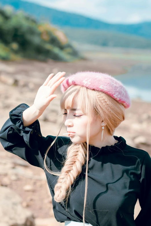 a woman standing on top of a beach next to a body of water, an album cover, inspired by Kim Jeong-hui, unsplash, realism, fluffy bangs, berets, blond hair with pigtails, ((pink))