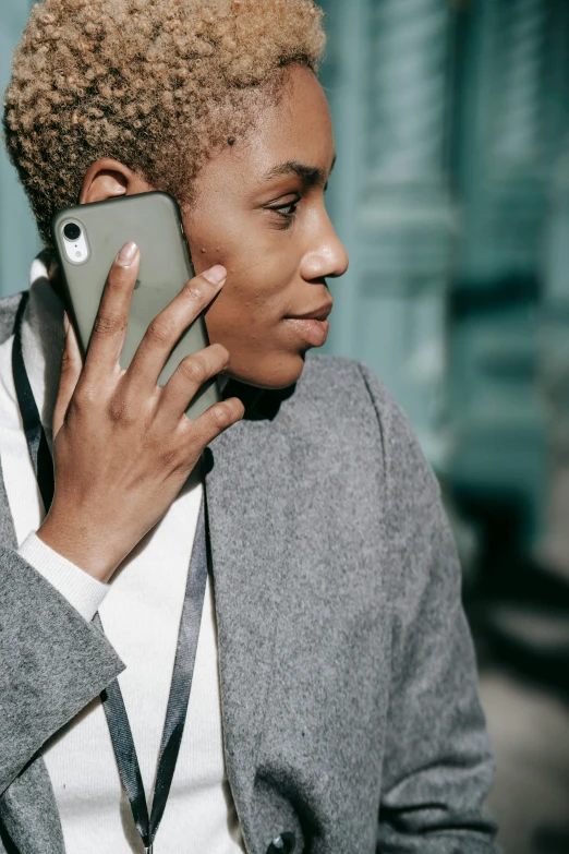 a close up of a person talking on a cell phone, trending on pexels, renaissance, dressed in a gray, dark skinned, androgynous person, cell cover style