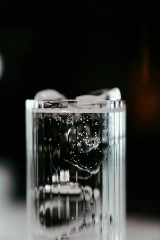 a glass filled with ice sitting on top of a table, inspired by Hendrick Goudt, unsplash, close up shot from the side, medium long shot, multiple stories, glassware