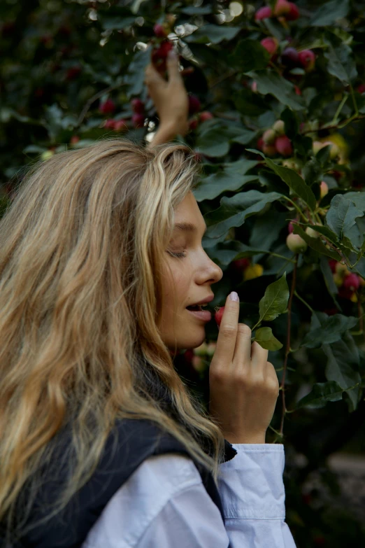 a woman picking raspberries from a tree, inspired by Elsa Bleda, trending on unsplash, sleepy fashion model face, nina agdal, praying with tobacco, with long blond hair