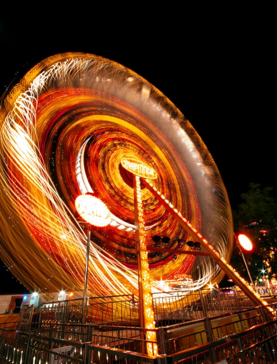 a blurry photo of a carnival ride at night, pexels contest winner, kinetic art, orange glow, profile image, super wide, a glowing halo