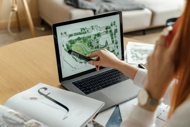 a woman sitting at a table using a laptop computer, a computer rendering, by Dan Content, pexels contest winner, architectural plans, green spaces, ready to model, no - text no - logo