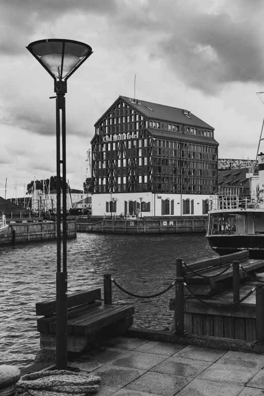 a black and white photo of a harbor, inspired by Wilhelm Marstrand, modernism, wooden buildings, full building, helmond, red building