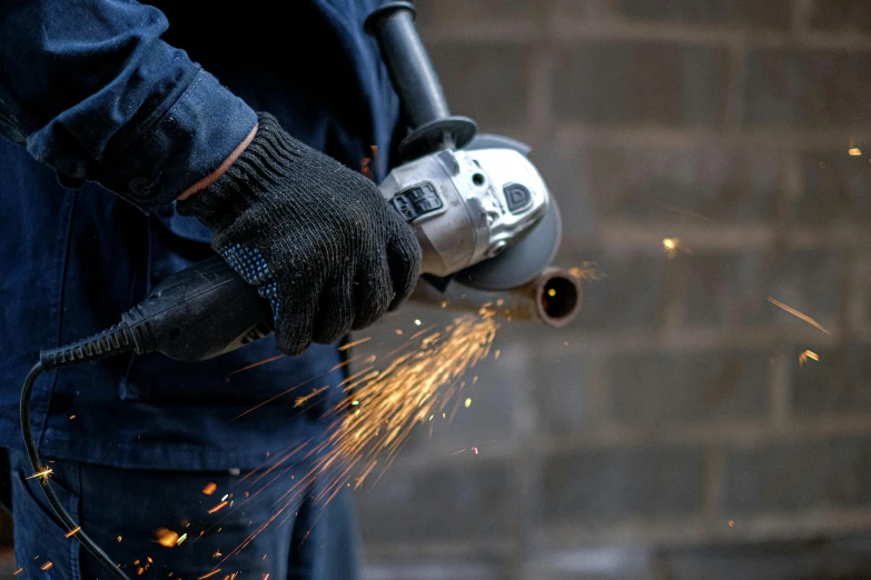 a close up of a person using a grinder, by Tom Bonson, pexels contest winner, arbeitsrat für kunst, gauntlets, islamic, stainless steel, profile image