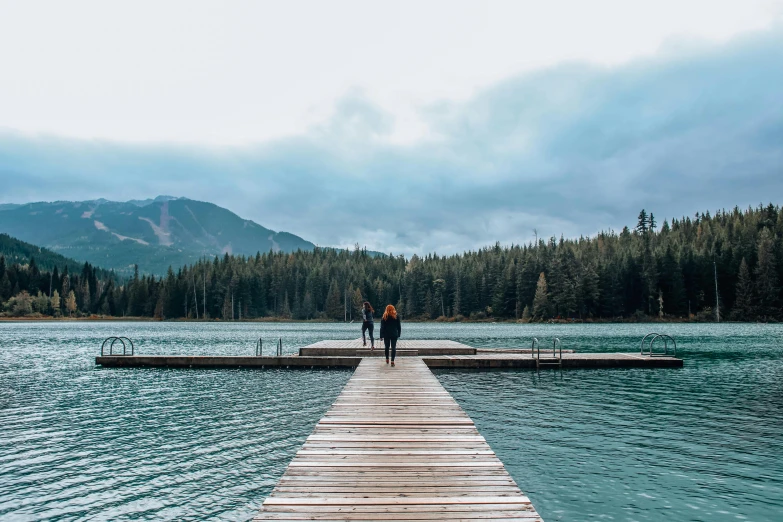 two people standing on a dock in the middle of a lake, by Jessie Algie, pexels contest winner, banff national park, walking to the right, erin moriarty, on a canva