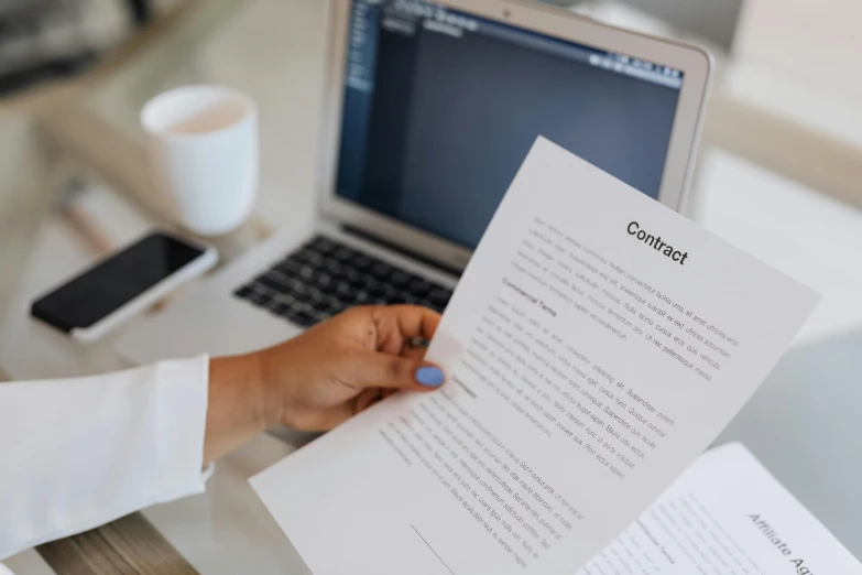 a person holding a piece of paper in front of a laptop, by Julia Pishtar, pexels contest winner, perfect readability, manuscript, high contract, instagram story