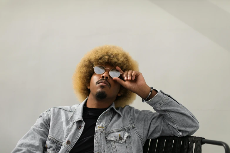 a man with an afro sitting on a chair, pexels contest winner, with sunglass, golden hair, jayison devadas, profile image