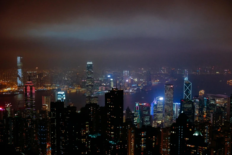 a view of a city at night from the top of a building, city like hong kong, gloomy lights in the sky, hazy, pc wallpaper