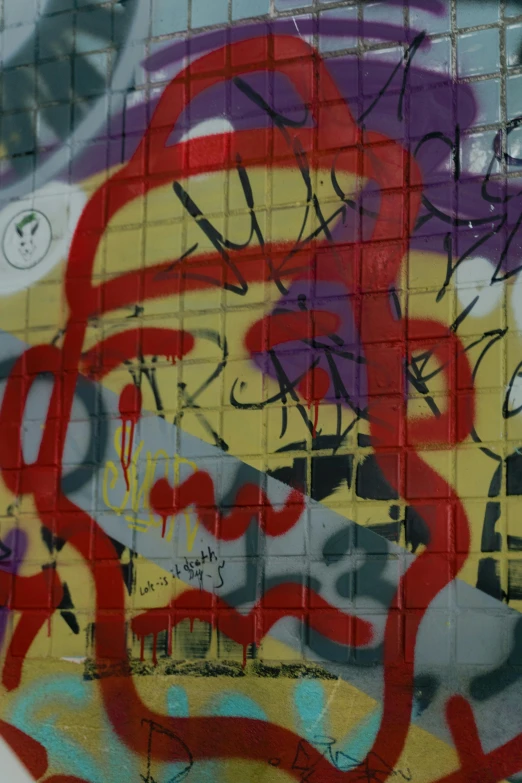 a red fire hydrant sitting in front of a graffiti covered wall, zoomed in, some red and purple and yellow, asemic writing, squares