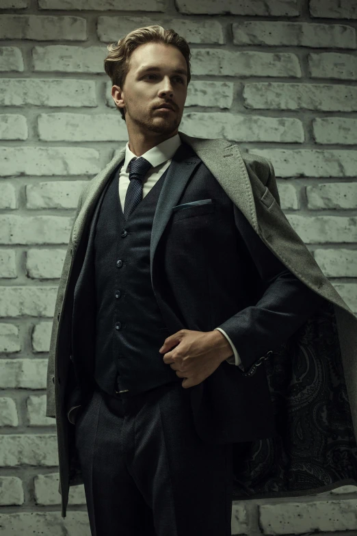 a man in a suit and tie standing in front of a brick wall, pexels contest winner, renaissance, elegant cape, model posing, ad image, studio shoot